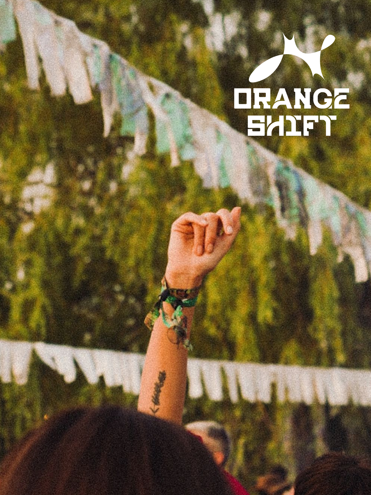 Orange Shift — raised hand with festival wristbands, bunting